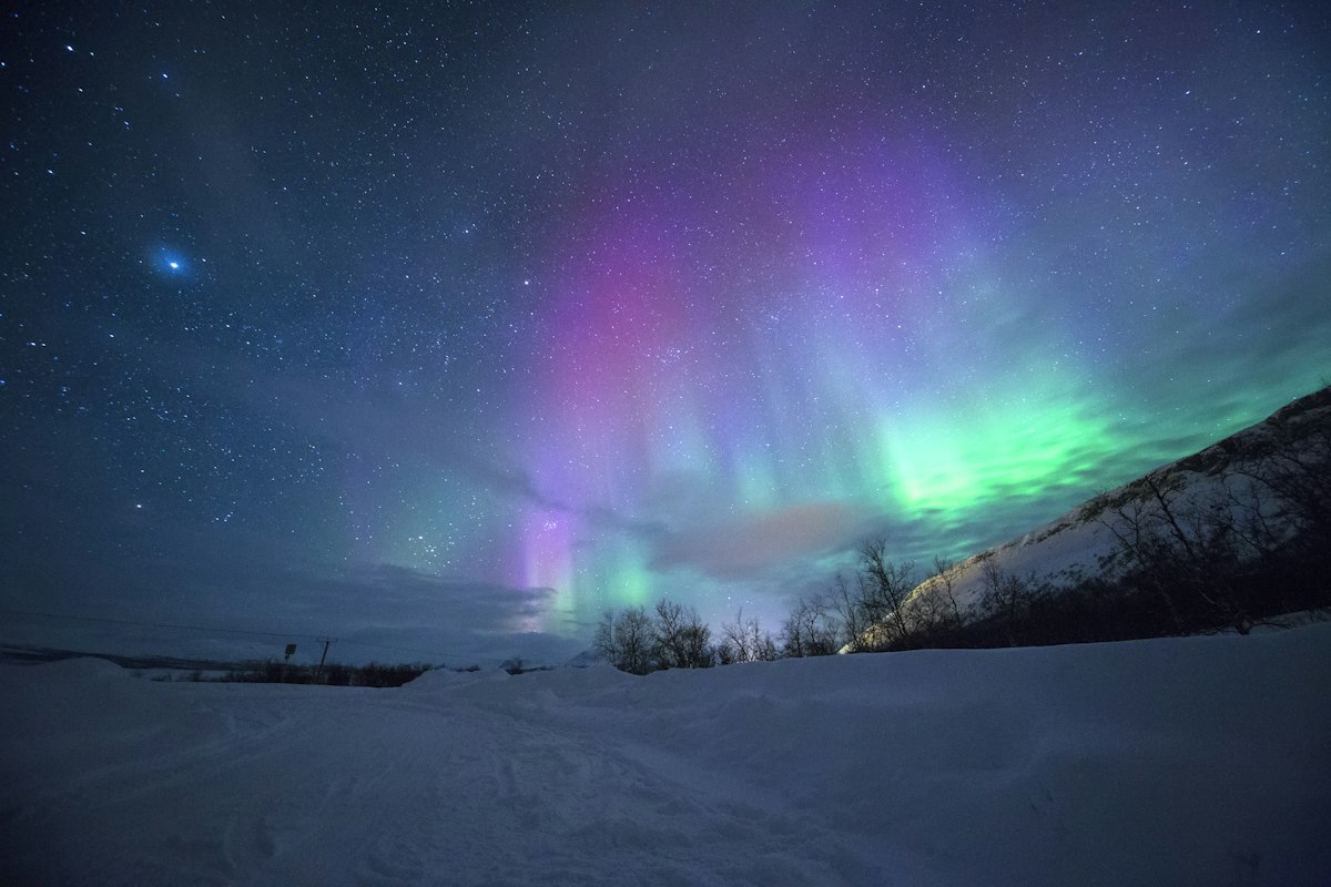 Cực quang trên những ngọn núi tuyết ở Tromsø