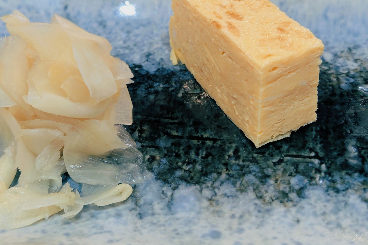 Trứng cuộn tamagoyaki và gừng hồng trên đĩa