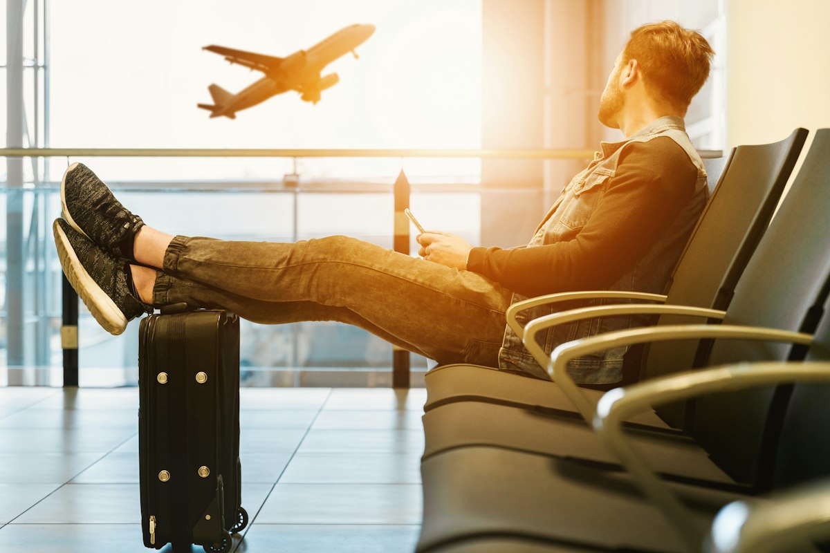 Hành khách ngồi chờ chuyến bay và ngắm máy bay tại sân bay