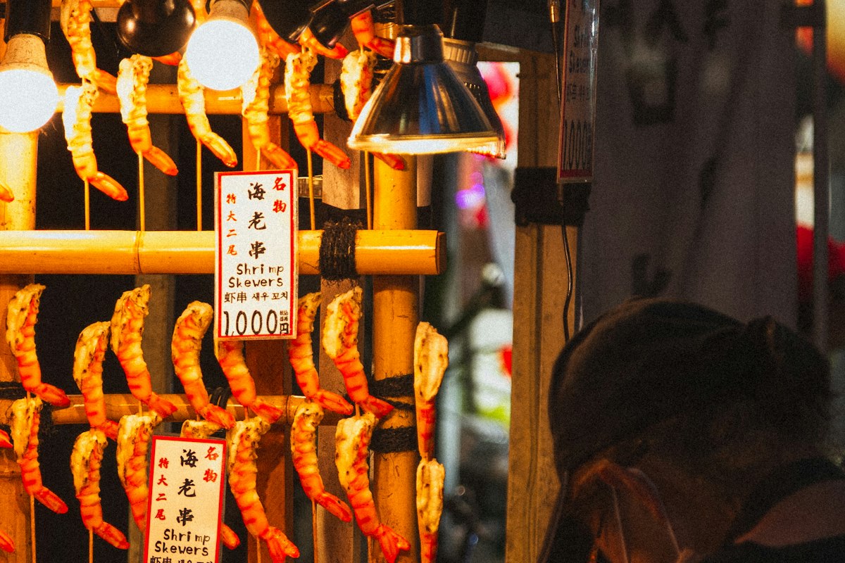 Đầu bếp nướng tôm tại một quầy ăn đường phố Nhật Bản
