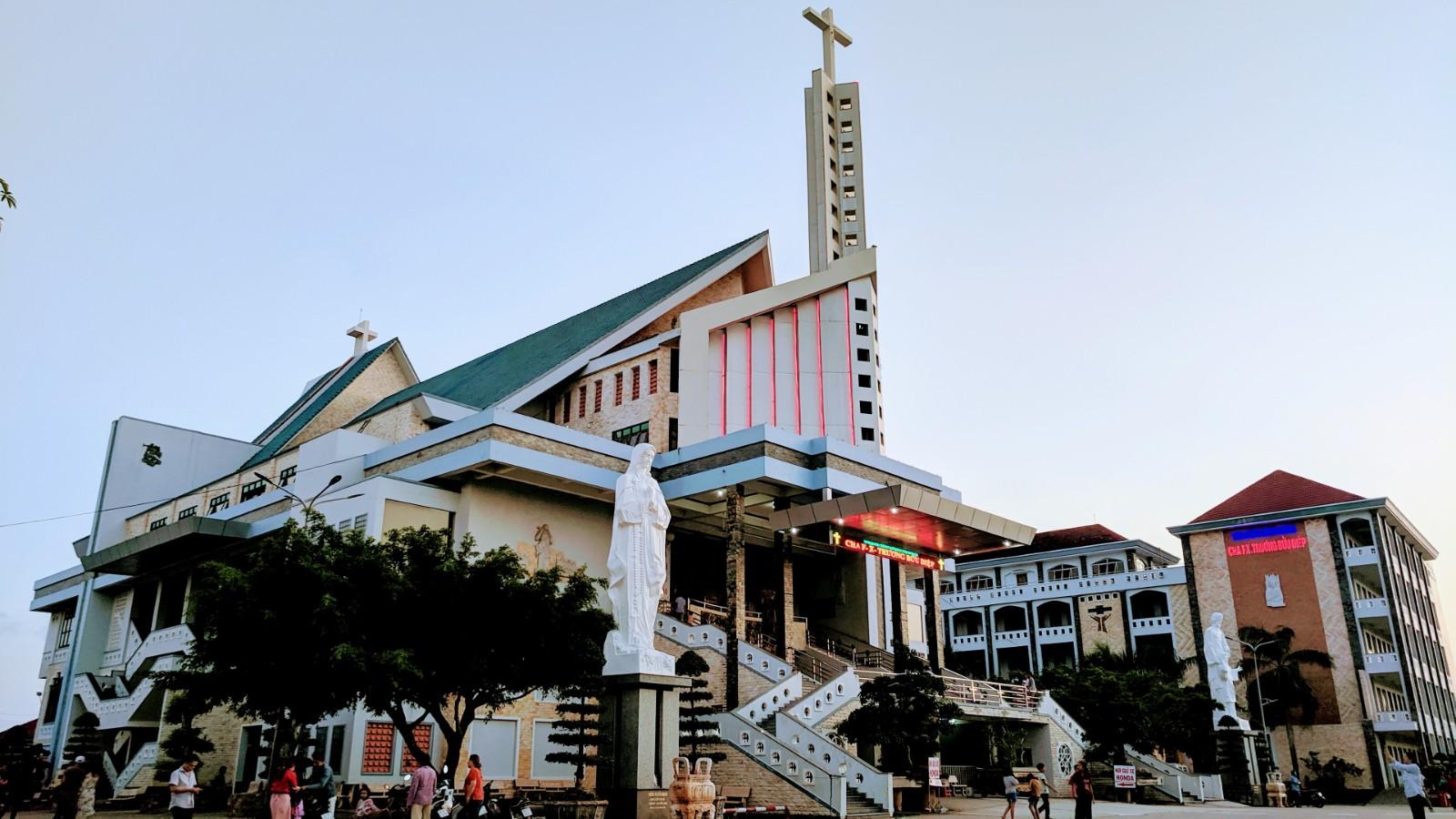 Faithful praying at Father Francis Truong Buu Diep’s tomb in Tac Say