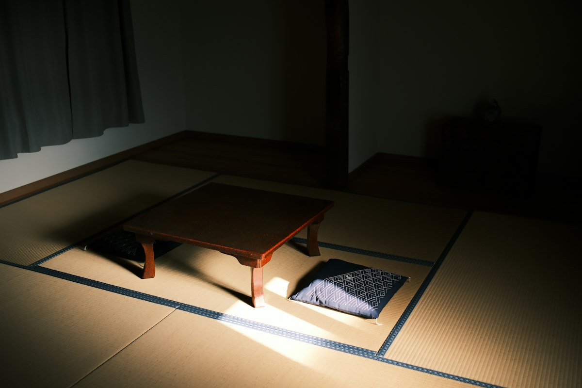 Bàn gỗ thấp và đệm ngồi trên chiếu tatami