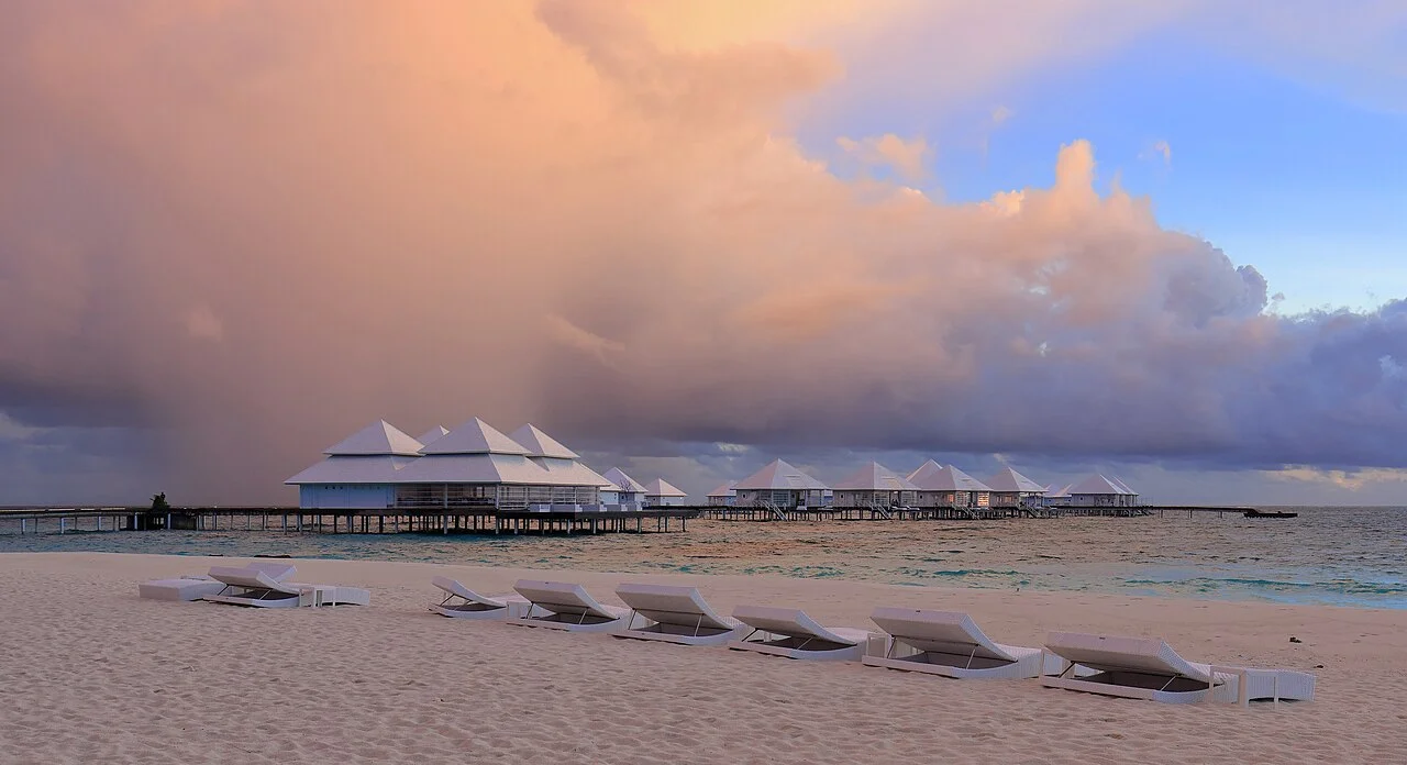 Dãy water villa và beach villa của resort Maldives lúc chiều tà