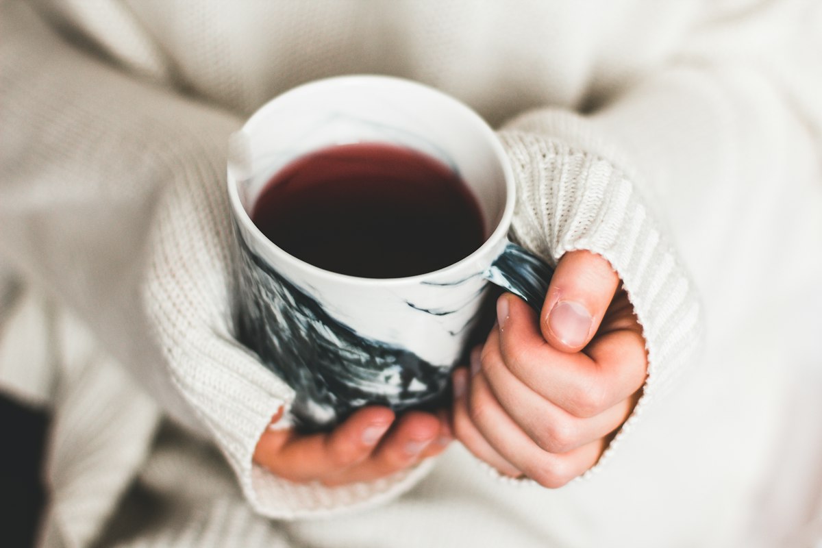 Cầm ly đồ uống nóng sưởi ấm