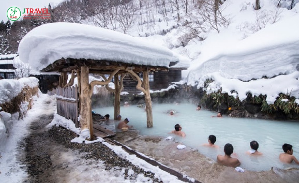 Trải nghiệm onsen ngoài trời mùa đông với núi phủ tuyết xung quanh