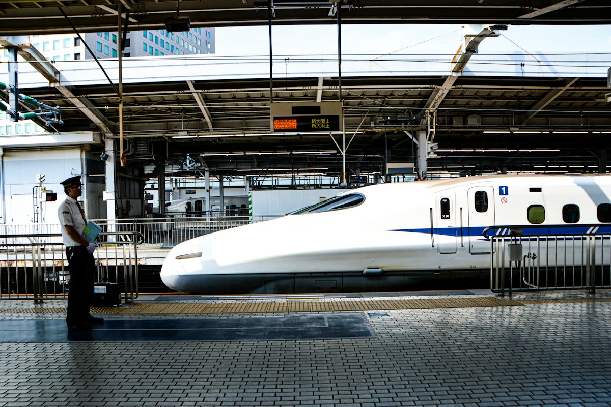 Nhân viên đứng trên sân ga khi tàu Shinkansen vào ga