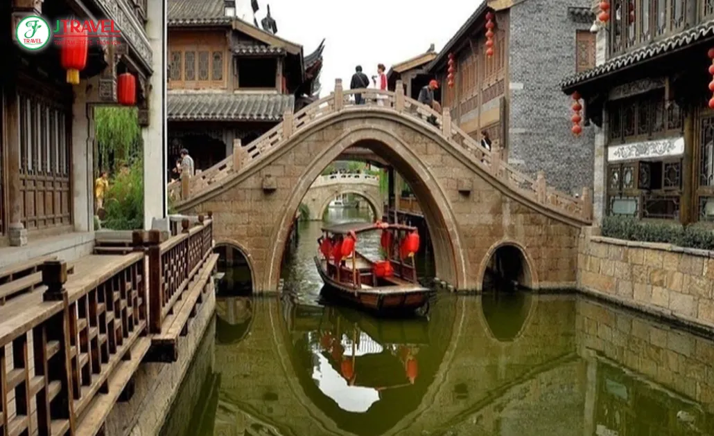 Kênh Đại Vận Hà Hàng Châu cổ kính với thuyền gỗ trôi qua cầu đá