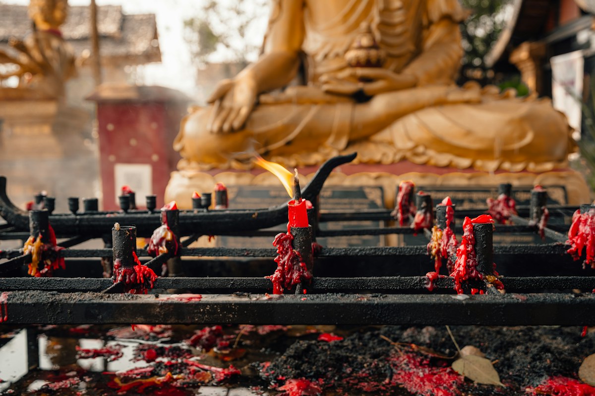 Những ngọn nến thắp sáng trước tượng Phật trong chùa ở Chiang Mai