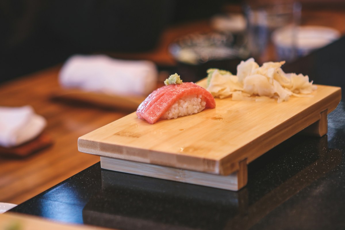 Sushi cá ngừ ăn kèm gừng hồng và wasabi trên đĩa gỗ