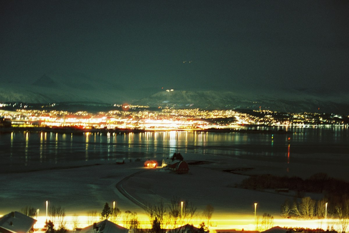 Ánh đèn thành phố Tromsø phản chiếu trên mặt nước về đêm