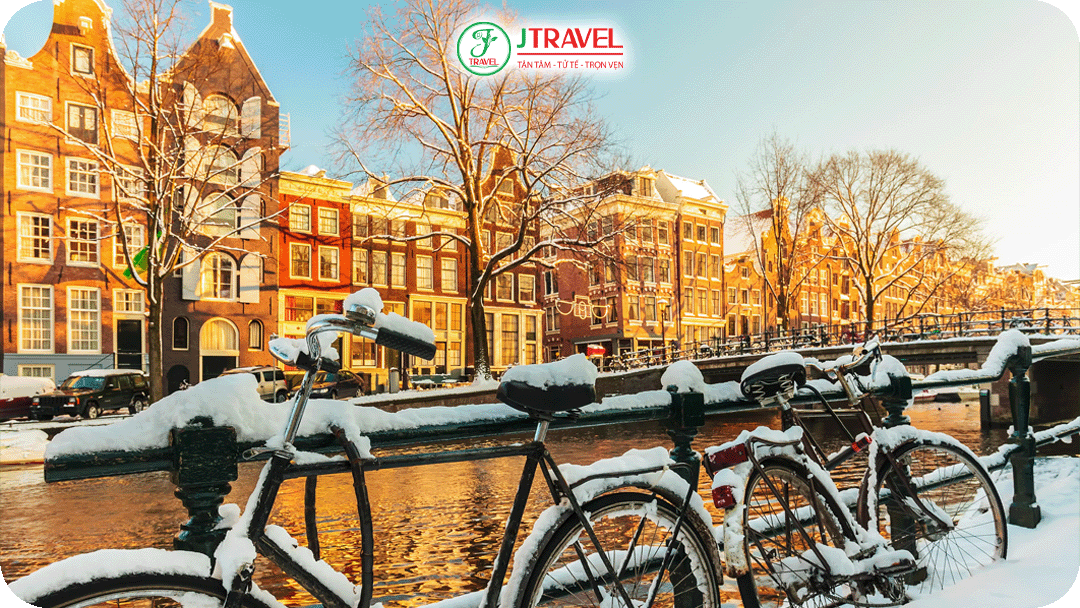 Amsterdam sáng sớm phủ lớp tuyết mỏng, ánh đèn phản chiếu trên mặt nước yên tĩnh