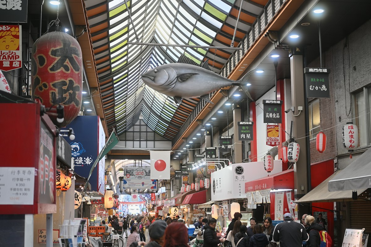 Du khách đi dạo trong con phố chợ có mái che ở Osaka