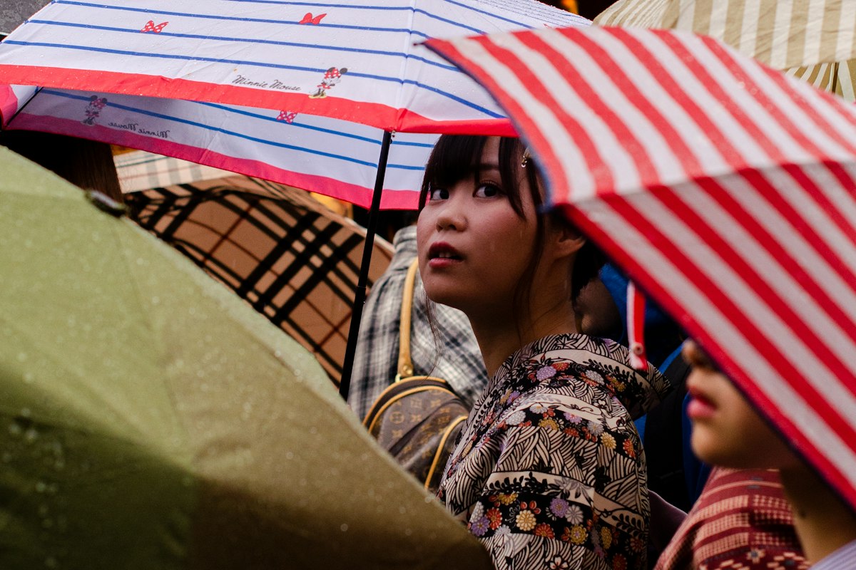 Hai người phụ nữ mặc kimono che dù đỏ trên phố Kyoto