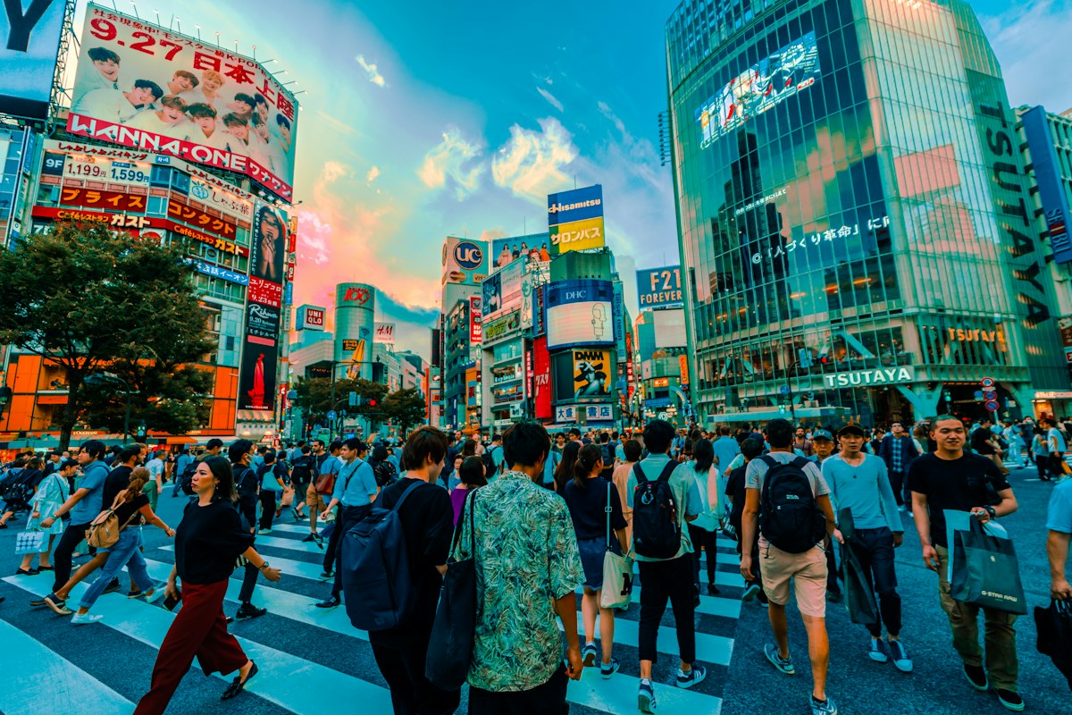 Dòng người đi bộ qua vạch kẻ đường giữa các tòa nhà ở Tokyo