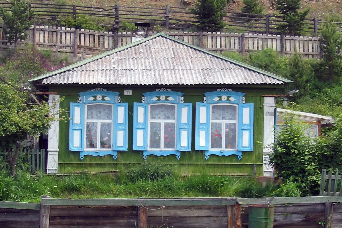Ngôi nhà gỗ chạm khắc truyền thống với khung cửa sổ xanh ở Irkutsk, Siberia
